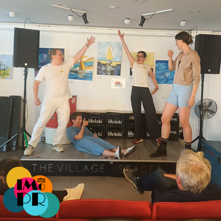 Afterwork Impro auf der nagelneuen The Village Bühne – super war’s und hat allen sichtbar viel Spaß gemacht. Egal ob zum ersten Mal dabei oder schon mit etwas Erfahrung – alle sind richtig in die Szenen eingetaucht. Das Bild zeigt 4 Personen in einer Szene auf der Bühne: eine liegend am Boden, zwei, die jeweils einen Arm jubelnd erhoben haben, und eine, die das Ganze kommentiert. Mit Afterwork Impro in den Feierabend starten, entdecke Improvisationstheater an coolen Orten! Afterwork Impro aus Hamburg veranstaltet Business- und Freizeit-Workshops mit den Methoden des Improtheaters.